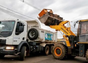 Caminhão da limpeza urbana recolhendo móveis e materiais descartados em bairro de Rio Preto.