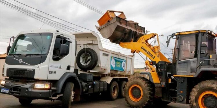 Caminhão da limpeza urbana recolhendo móveis e materiais descartados em bairro de Rio Preto.