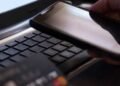 Idosa analisando extrato bancário com saldo reduzido após fraude financeira.