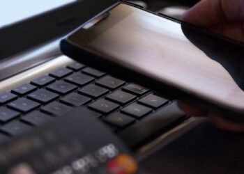 Idosa analisando extrato bancário com saldo reduzido após fraude financeira.