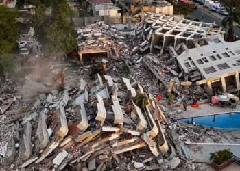 Equipes de resgate trabalham entre escombros após terremoto na Venezuela.