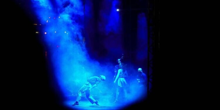 Palco de teatro iluminado durante apresentação cultural no FIT Rio Preto.
